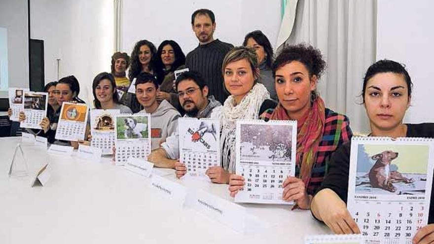 Los artistas e integrantes de &quot;Os Palleiros&quot; con el calendario artístico que lanza la asociación