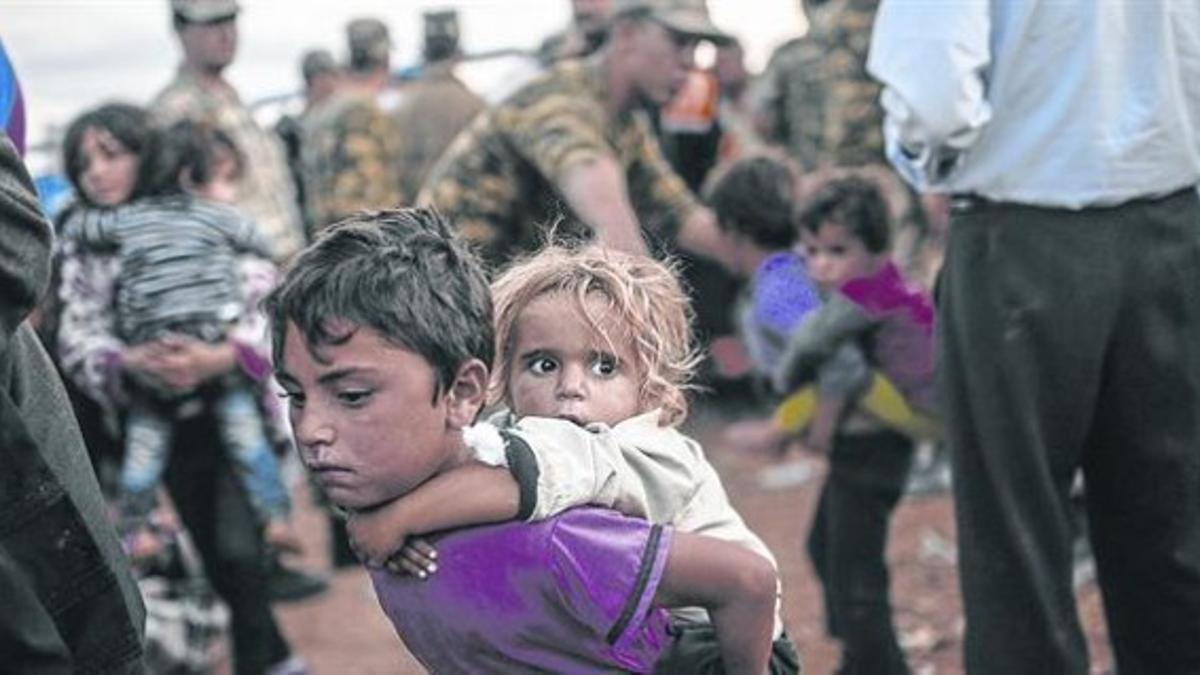 Varias familias kurdas de Siria llegan a la frontera con Turquía huyendo de los combates, el pasado lunes.