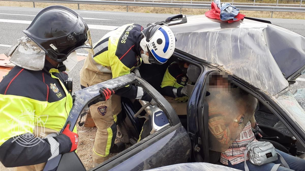 Bomberos atienden a una de las mujeres heridas tras el accidente.