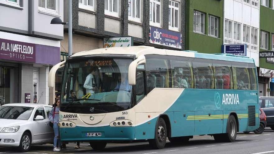 Un autobús interurbano recolle viaxeiros na avenida de Fisterra de Arteixo.