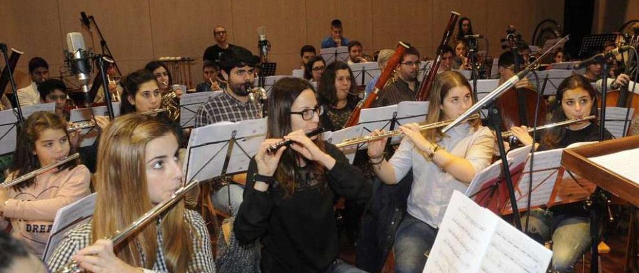 Los músicos de la banda, ayer en el auditorio de Ribadumia durante la grabación. // Noé Parga