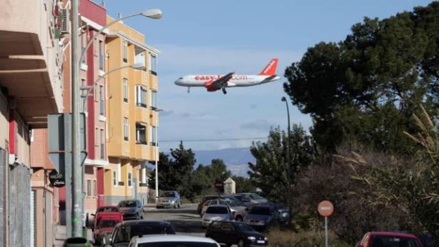 Viviendas en El Altet y un avión que se dispone a tomar tierra en el aeropuerto.