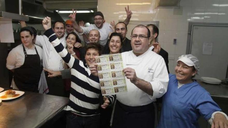 El propietario del restaurante La Cantera, con la serie premiada en la mano, junto a familiares y trabajadores, ayer al mediodía.