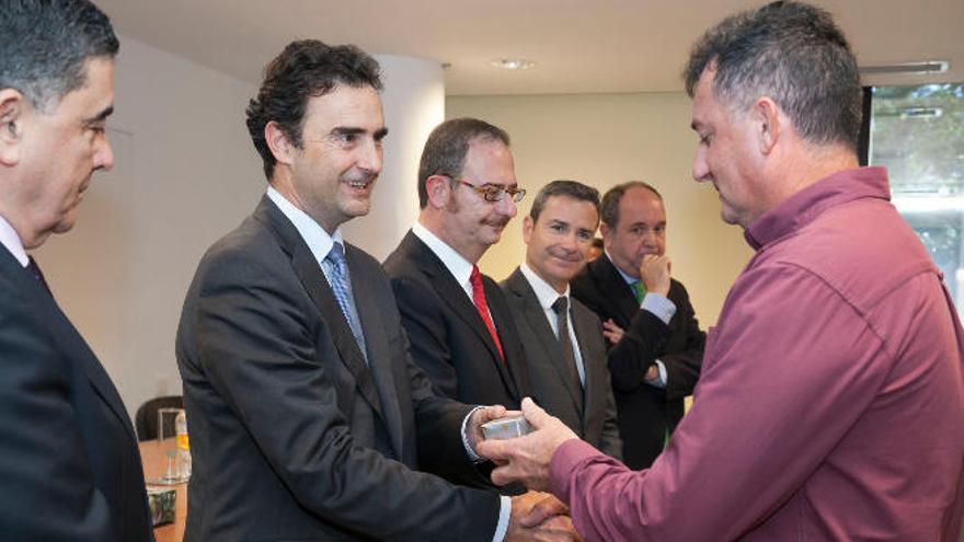 Pablo Casado entrega una insignia a uno de los empleados homenajeados.