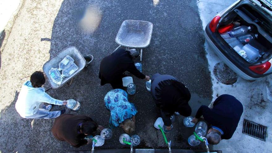 Vecinos de la provincia recogen agua en botellas.