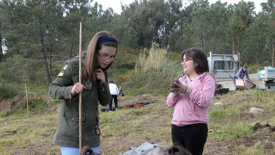 Alumnas del IES durante la plantación de ayer en Testos. // N. P.