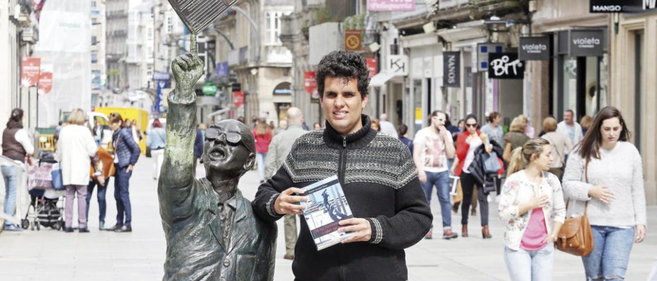 Daniel Antomil posa con su libro ante la estatua de Castro, emblemático vendedor de periódicos vigués. // Marta G. Brea