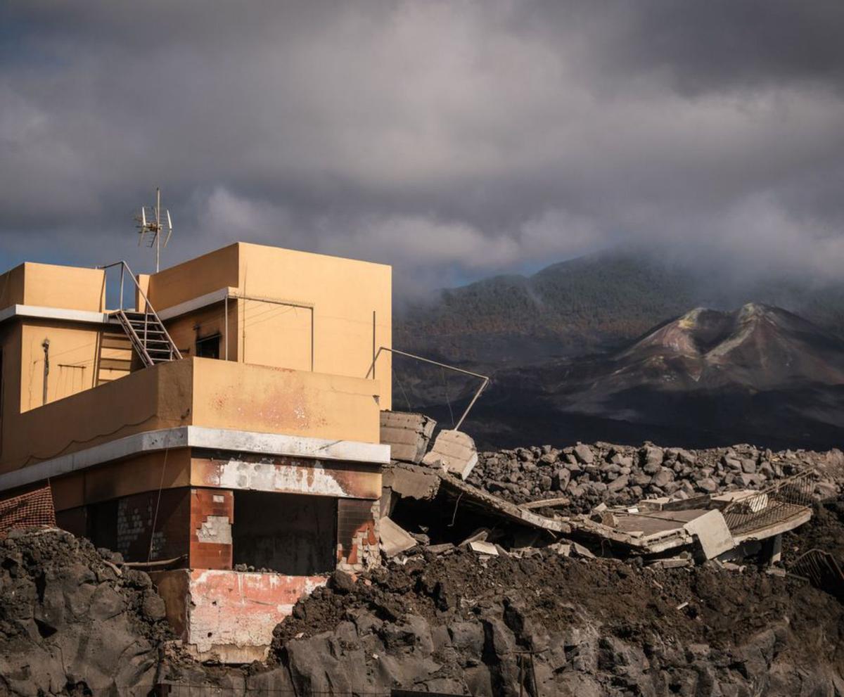 Una de las casas afectadas con el volcán Tajogaite de fondo. | | A. GUTIÉRREZ