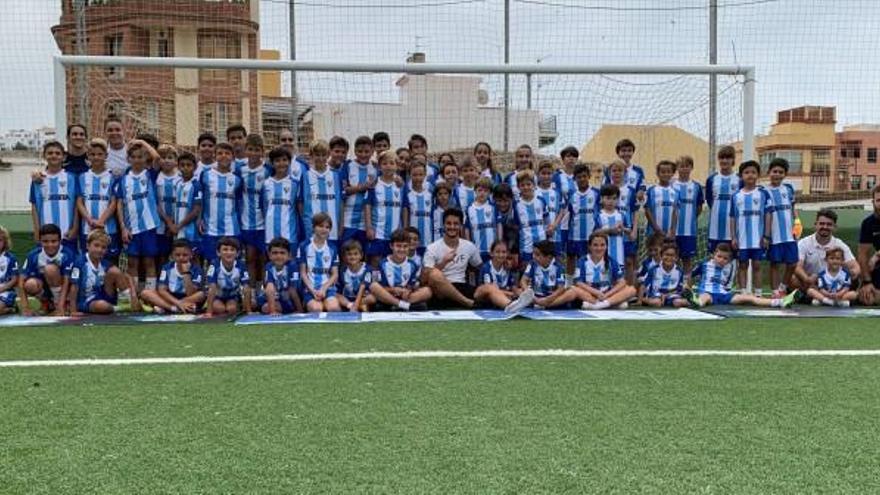 El jugador del Málaga, Juankar, junto a los niños que participan en el campus.