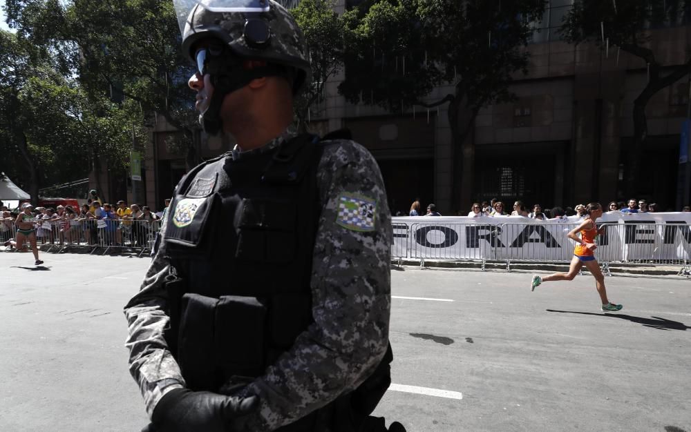 Un atleta pasa ante un cartel que clama por la destitución de Temer, presidente interino de Brasil.