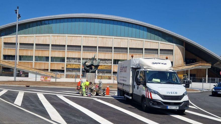 Operarios pintan líneas sobre la calzada tras la apertura del tráfico junto a la fachada principal del Palacio.