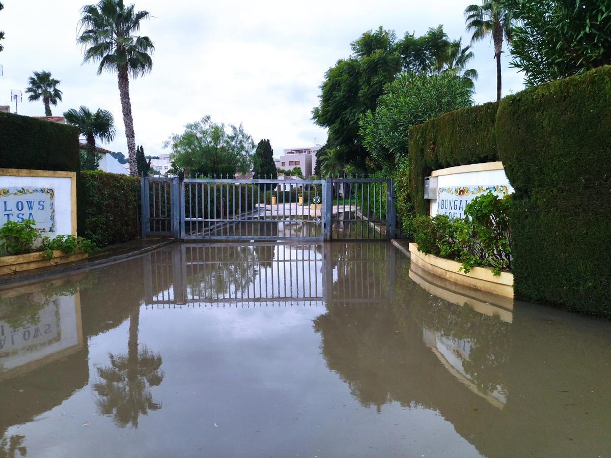 El acceso inundado a una de las urbanizaciones de la carretera del Cap de la Nau