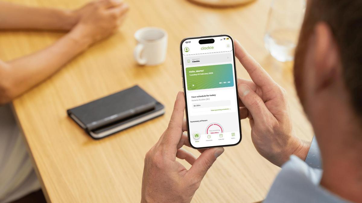Un treballador mirant la pantalla d'inici de l'aplicació Clockio.net.