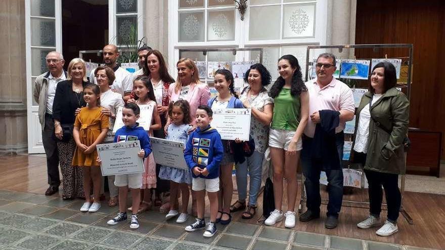 Los niños premiados en el concurso &quot;Debuxa a túa provincia&quot; con sus familias y Carmela Silva. // S. R.