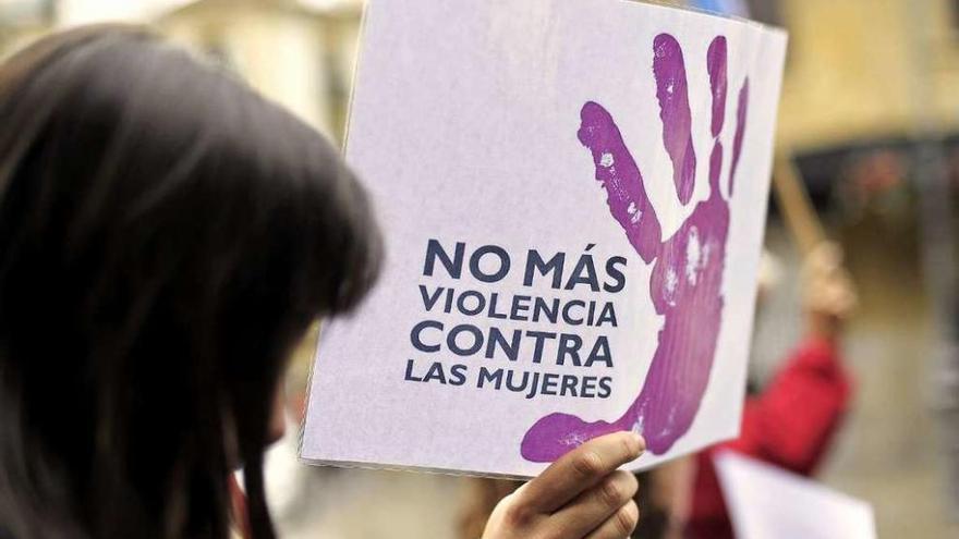 Una joven porta un cartel contra el maltrato en una manifestación contra la violencia de género. // Efe