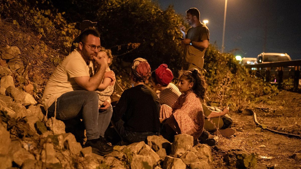 01 October 2024, Israel, Tel Aviv: People take cover on a road side in Tel Aviv, during a warning of incoming missiles launched from Iran. Photo: Ilia Yefimovich/dpa