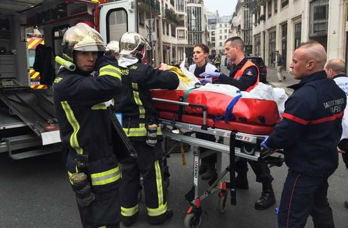 Els bombers traslladen a un ferit en llitera, després de l’atemptat.
