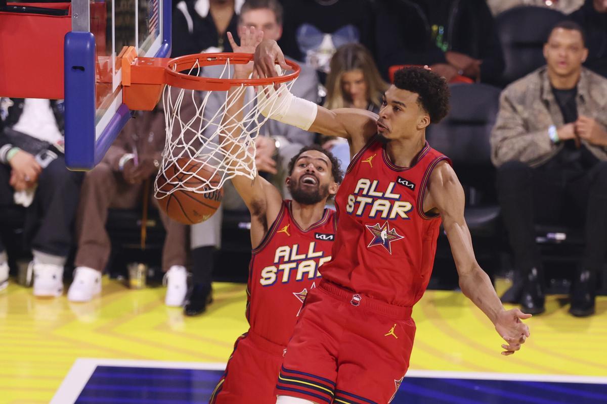 San Antonio Spurs center Victor Wembanyama dunks past teammate Trae Young during the NBA All-Star basketball game Sunday, Feb. 16, 2025, in San Francisco. (AP Photo/Jed Jacobsohn)