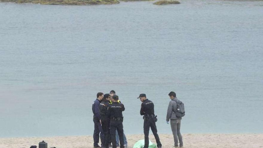 Agentes del Cuerpo Nacional de Policía, con el cadáver de la mujer hallada en el agua.