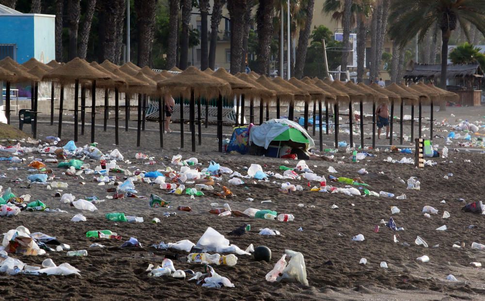 Los operarios de los servicios de limpieza trabajan para dejar la playa en óptimas condiciones tras una larga noche de fiesta en la arena