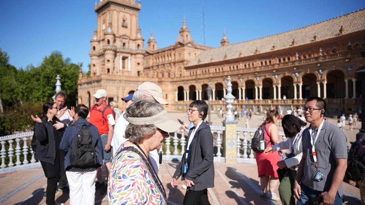 Turistas pasean por la Plaza de España de Sevilla, uno de los municipios que la Junta de Andalucía considera que están saturados de visitantes.