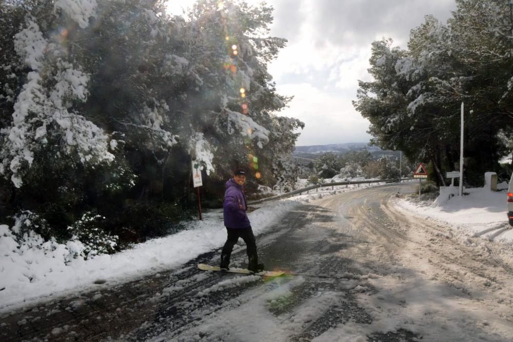 Un joven practicando snowboard por la carretera de les Planes.