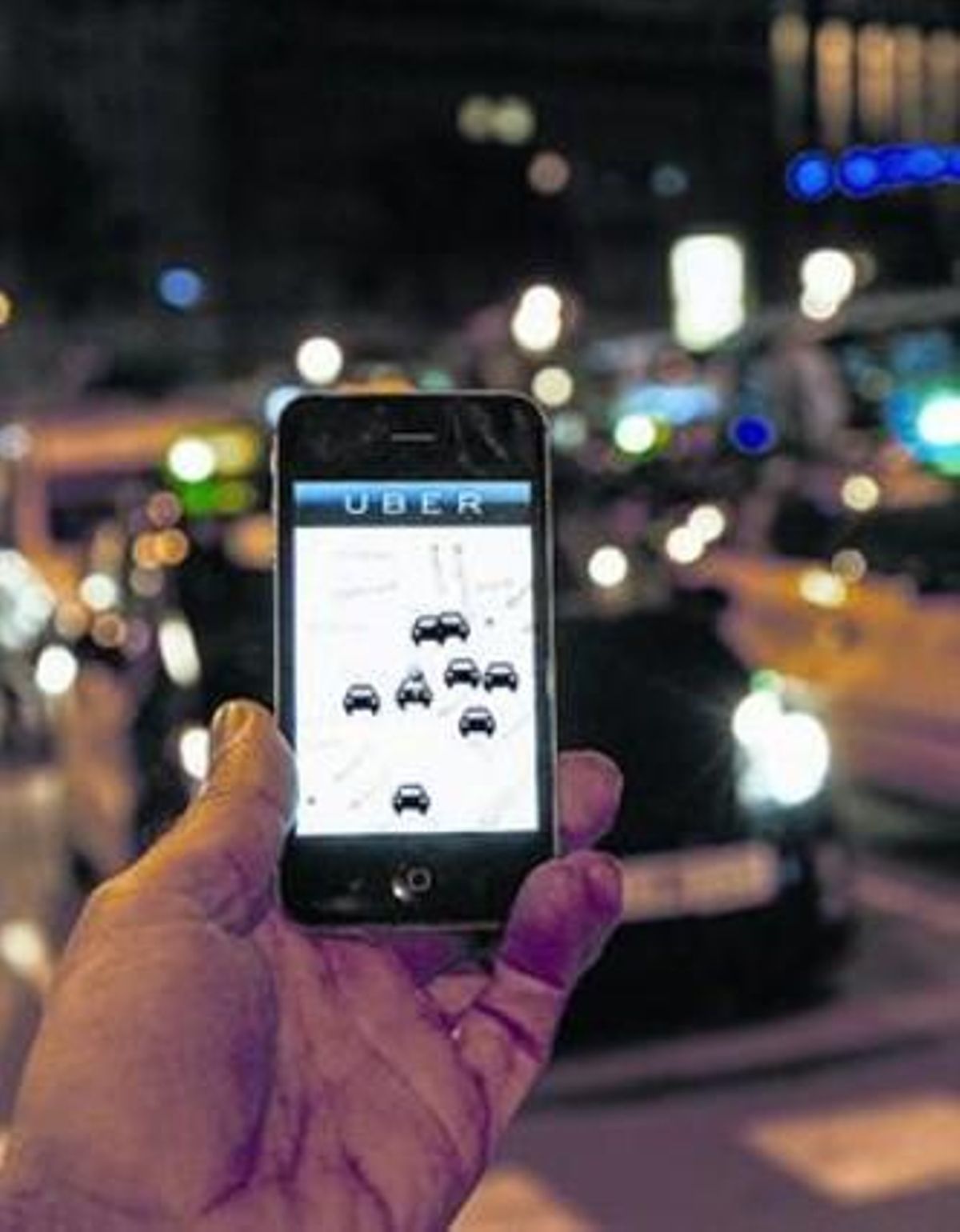 Un usuari consulta l’’app’ d’Uber davant un taxi, al passeig de Gràcia. Un usuari consulta l’’app’ d’Uber davant un taxi, al passeig de Gràcia.