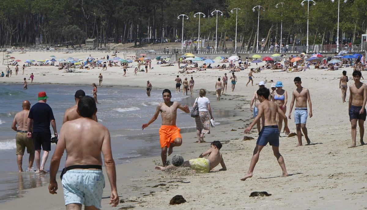 Jóvenes jugando al fútbol en la playa.
