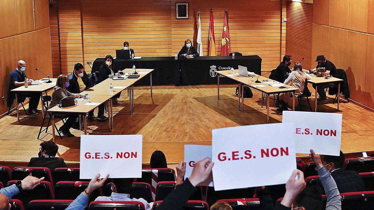 Unas personas del público muestran pancartas contra la creación del GES durante el pleno. |   // P. HERNÁNDEZ