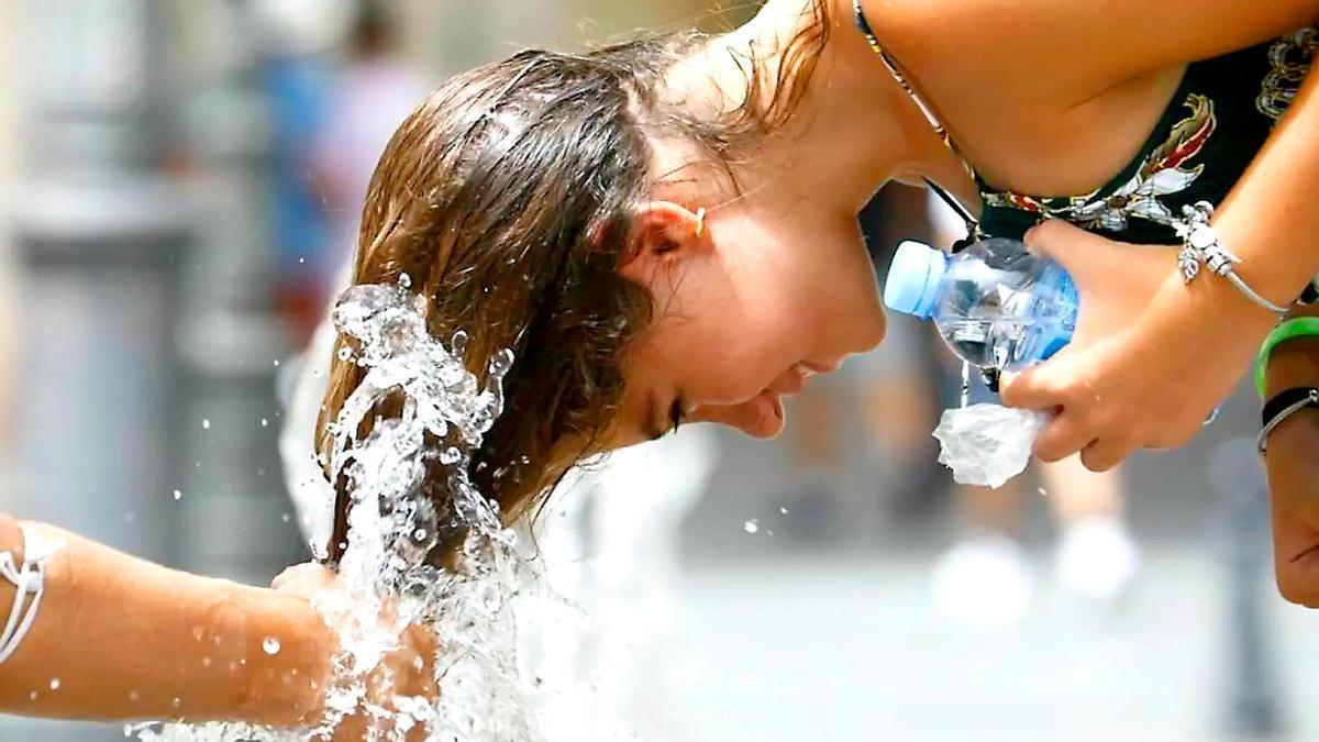 Una joven se refresca frente a la ola de calor.