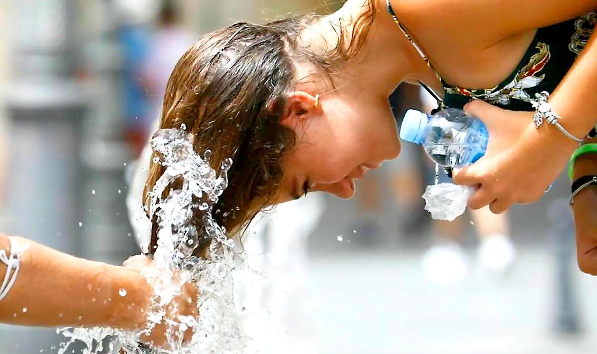 Una joven se refresca frente a la ola de calor.