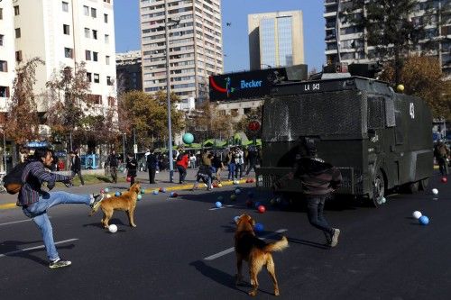 Students kick soccer balls against riot police during a demonstration to demand changes in the education system, in Santiago