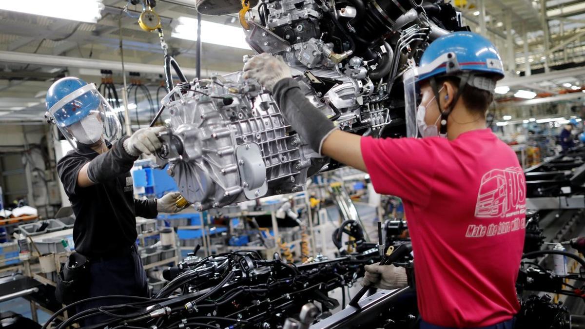 Dos trabajadores en una línea de producción de Daimler en Japón.