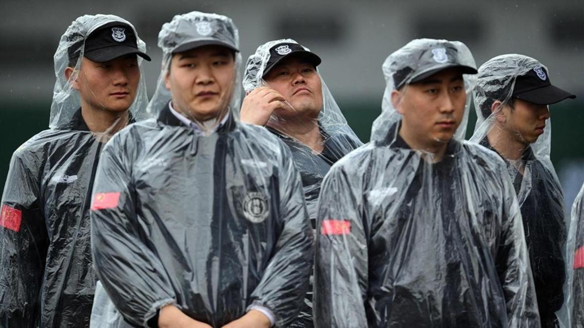 Seguridad con el uniforme de lluvia cerca del paddock