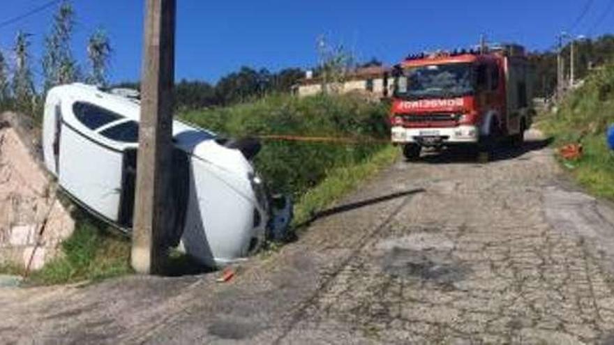 Los bomberos tratan de enderezar el vehículo. // Emerxencias Sanxenxo