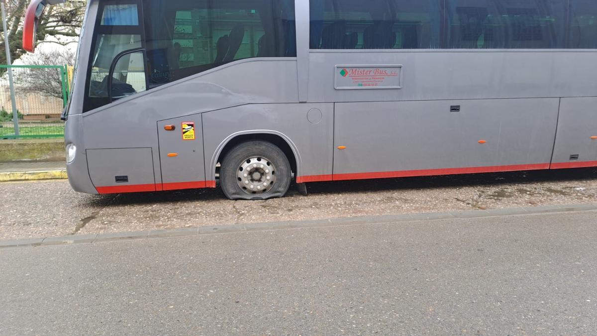 Uno de los autobuses escolares que hace la ruta desde Albero Alto hasta Huesca, con la rueda pinchada.