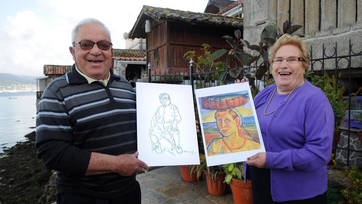 Antonio Besada y Maruja Vicente, en Combarro, con sendas reproducciones de los retratos que les hizo Carlos Maside en 1952.