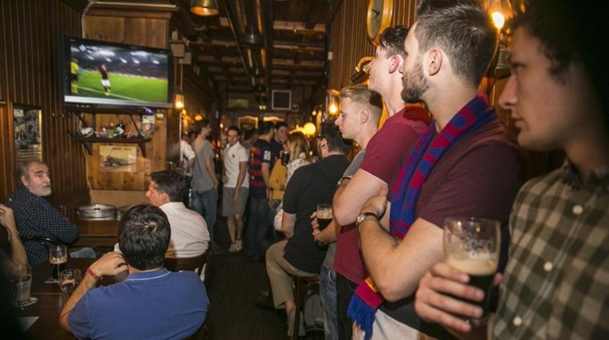 Clients del bar The Philharmonic, de Barcelona, segueixen per televisió el partit de Champions Roma-Barça. Clients del bar The Philharmonic, de Barcelona, segueixen per televisió el partit de Champions Roma-Barça.