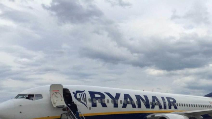 Varios viajeros, dirigiéndose a un avión de Ryanair en la pista del aeropuerto de Santander.