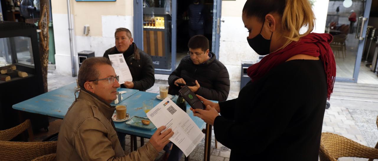 Archivo - Una camarera pide certificado a los clientes en una mesa en la terraza de un bar