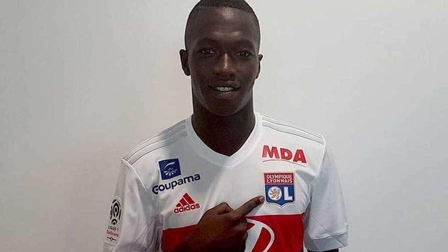 Pape Cheikh señala el escudo del Olympique Lyonnais, su nuevo equipo.