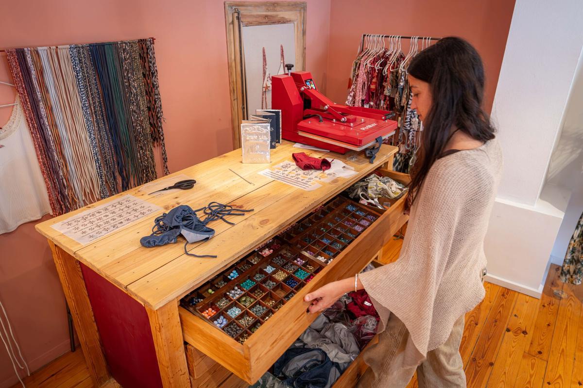 Camila Carles-Tolrá Galofré organizadora de la primera Bikini Lab muestra los adornos existentes para customizar los bikinis. La Bikini Lab es un taller viral en el que los asistentes pueden confeccionar su propio bikini en menos de dos horas en Camila CTG, Calaf 14. Barcelona, 19 de mayo de 2026. Barcelona. AUTOR: Manu Mitru | EPC
