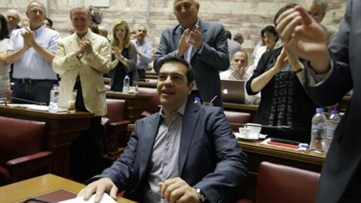 Alexis Tsipras, ayer, aplaudido por los diputados de Syriza en el Parlamento.