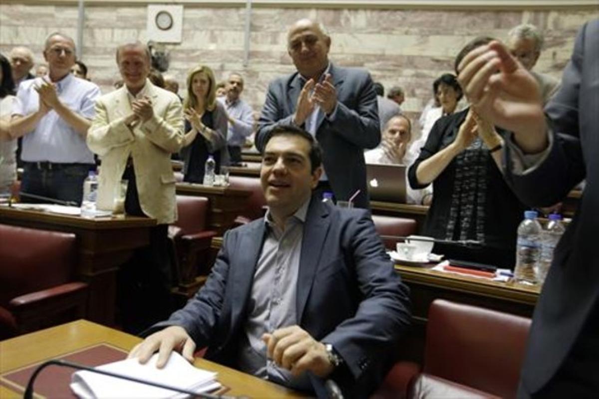 Alexis Tsipras, ayer, aplaudido por los diputados de Syriza en el Parlamento.