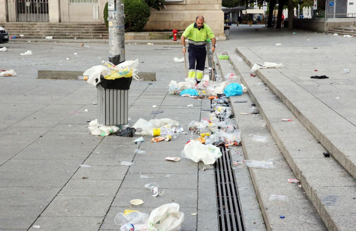 Barrendero limpia los restros de un macrobotellón de Halloween en Vigo. |   // MARTA G. BREA