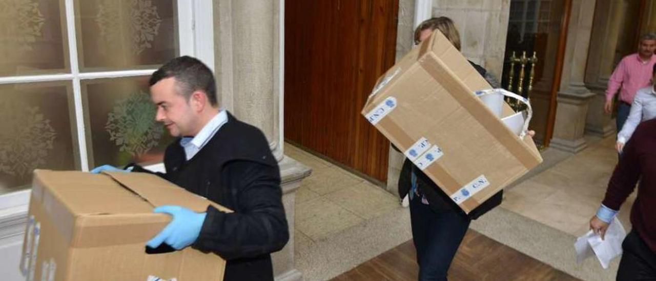 Dos policías retiran en 2014 cajas con documentación de la Diputación en la Operación Patos. // G. S.