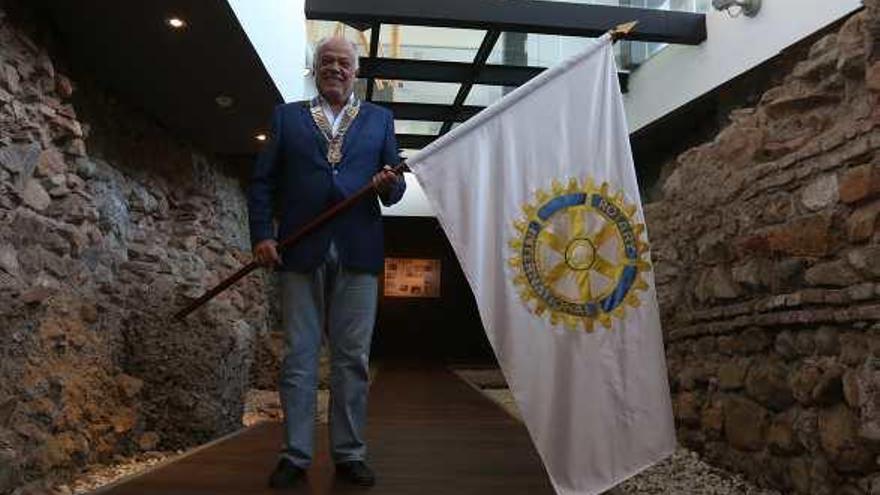 Cayetano Benzo con la bandera rotaria junto a la muralla nazarí integrada en el Hotel Posada del Patio,