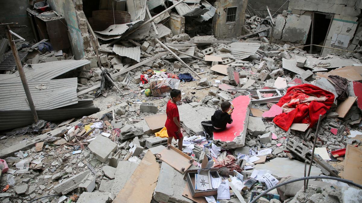 Dos niños inspeccionan las ruinas de una casa, destruida tras un bombardeo israelí.