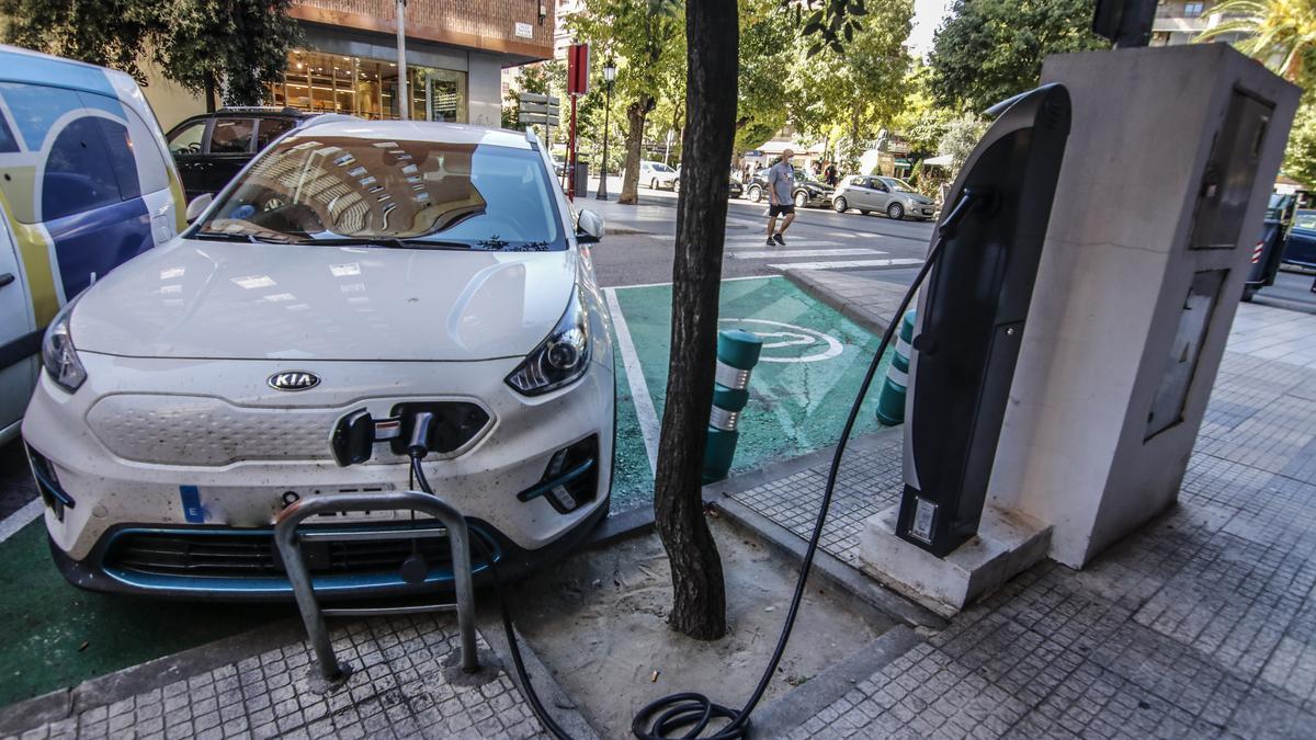 Un vehículo eléctrico recarga en un punto situado en una calle cacereña el pasado viernes.