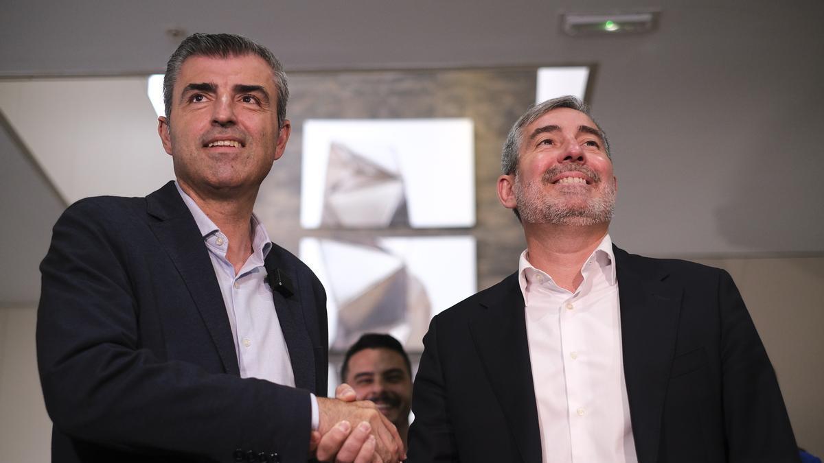 El secretario general de Coalición Canaria, Fernando Clavijo (i), y el presidente del PP en las islas, Manuel Domínguez (i), comprueban una información en el móvil durante la reunión en la que los dos partidos han avanzado en su acuerdo para constituir un Gobierno de coalición en la comunidad autónoma, con Clavijo